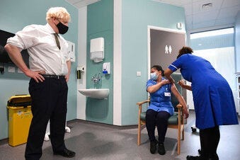 Britain's Prime Minister Boris Johnson watches as nurse Jennifer Dumasi is injected with the Oxford-AstraZeneca Covid-19 vaccine. (Stefan Rousseau/Pool Photo via AP)