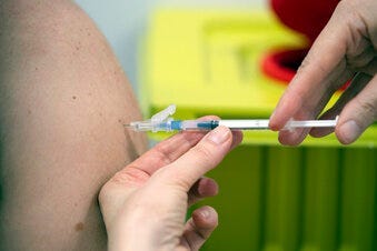 A member of staff at the university hospital injects the Moderna vaccine against COVID-19 into a patient in Duesseldorf, Monday, Jan. 18, 2021. (Federico Gambarini/dpa via AP)