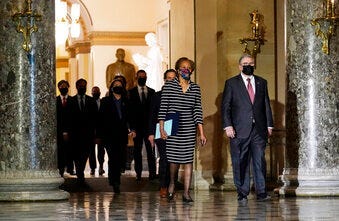 Clerk of the House Cheryl Johnson along with acting House Sergeant-at-Arms Tim Blodgett, lead the Democratic House impeachment managers as they walk through Statuary Hall in the Capitol. (AP Photo/Susan Walsh)