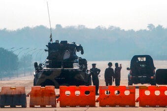 Myanmar's military stand guard at a checkpoint manned with an armored vehicle in a road leading to the parliament building Tuesday, Feb. 2, 2021, in Naypyitaw, Myanmar. (AP Photo)
