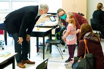 Washington Gov. Jay Inslee, left, talks with a student as teacher Alyson Lykken, center, looks on, Tuesday, Feb. 2, 2021, during a visit to a low-incidence disability classroom at Elk Ridge Elementary School in Buckley, Wash. (AP Photo/Ted S. Warren)