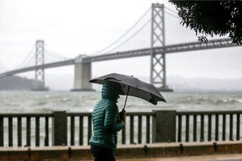 A cold weather front brings clouds skies and rainstorms to downtown San Francisco, Calif., on Sunday, Dec. 12, 2021. Meteorologists say the storms are just the beginning of an "atmospheric river" that will bring more intense rainfall and heavy snow in the Sierras. A significant storm ramped up Sunday with snow in Northern California that forced drivers to wrap their tires in chains and light rain in the lower elevations. The storm promises to drop up to 8 feet of snow on the highest peaks and drench other parts of the state.