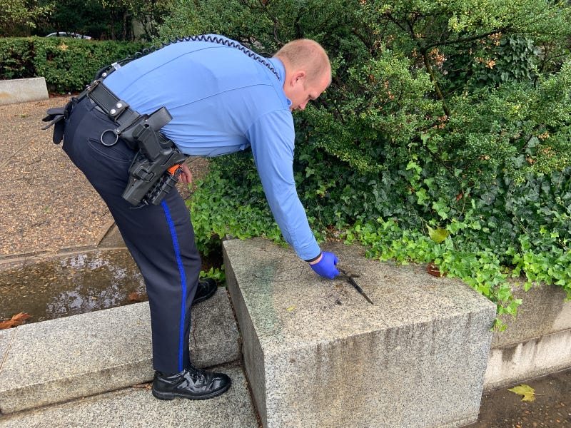A Philadelphia police officer analyzing a gun-like object which Antonio Hernandez fished out of the Schuylkill River.