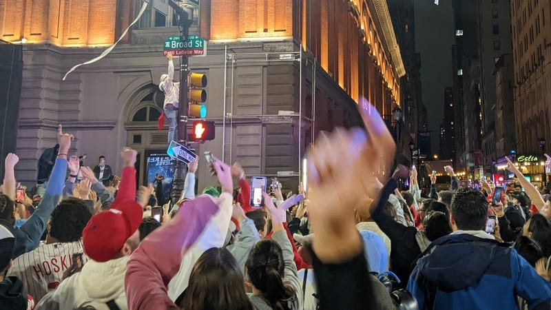 A Phillies fan defies Philadelphia police, gravity and slippery hydraulic fluid to climb a pole in celebration of the Phillies' NLCS victory on Sunday.