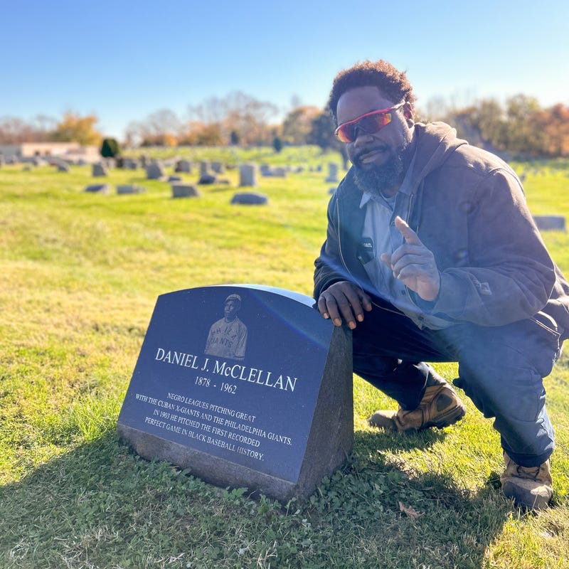 Hakeem Thomas Sr., superintendent of Eden Cemetery in Collingdale, Pa., poses by the headstone of legendary Negro Leagues pitcher Daniel McClellan.