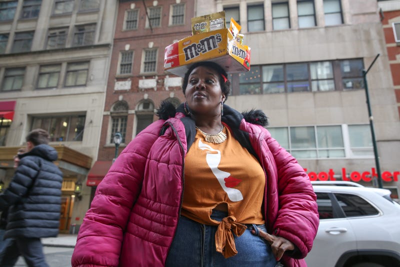 The Candy Lady poses with her signature M&M box on top of her head in Center City.