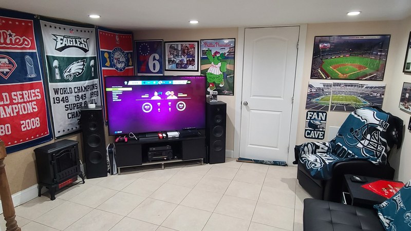 Alvah Brown and Kim West have decked out their West Oak Lane basement -- or “Fam Cave” -- with photos, paraphernalia, gear and other items celebrating Philadelphia sports.