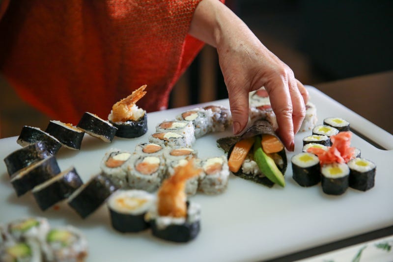 Madame Saito presents an array of sushi rolls, which she teaches others how to make in her classes.