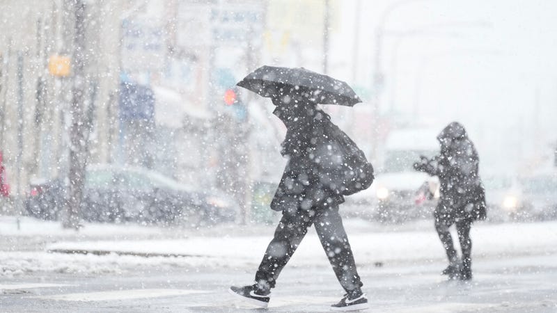 People cross a street during a winter snow storm in Philadelphia on Tuesday.