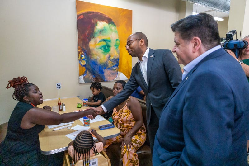 A woman shakes Christian Mitchell’s hand at a campaign event hosted by Peach’s Restaurant in Chicago’s Bronzeville neighborhood on July 2.