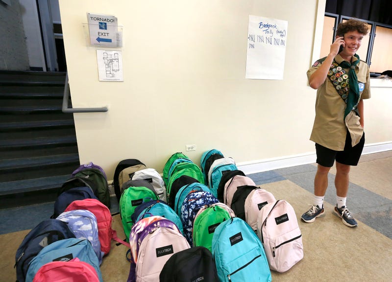 Harrison Mellon stands next to dozens of backpacks. The 16-year-old led a donation effort in Chicago to help provide migrant children with supplies for the upcoming school year.