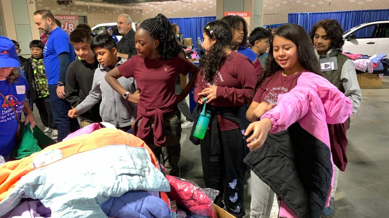 School children select coats donated to the Driving Away the Cold program by area auto dealers.
