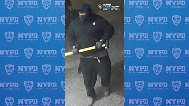 One of several suspects is seen wielding a sledgehammer during the brazen burglary in Jackson Heights last Friday evening