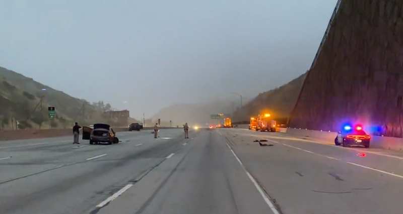 freeway shut down with wrecked car in lane and police cars on shoulder