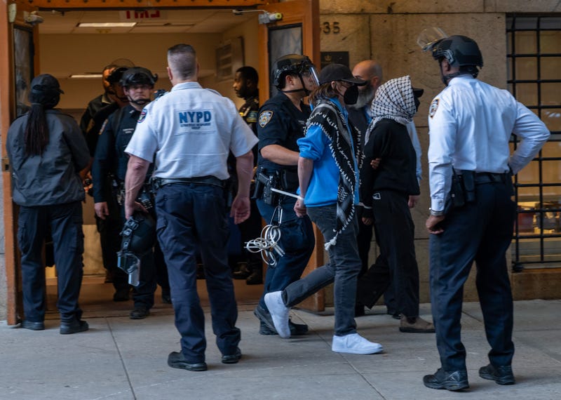 Protesters are escorted out of Columbia University's Butler Library after their arrest for occupying the library space in New York City, on May 7