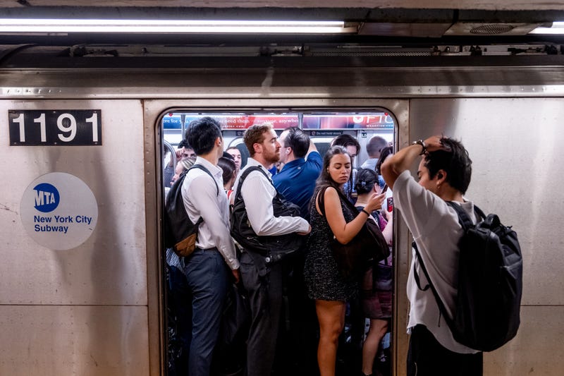 Commuters board a train at the 14th Street-Union Square subway station during high temperatures in New York on June 23, 2025.