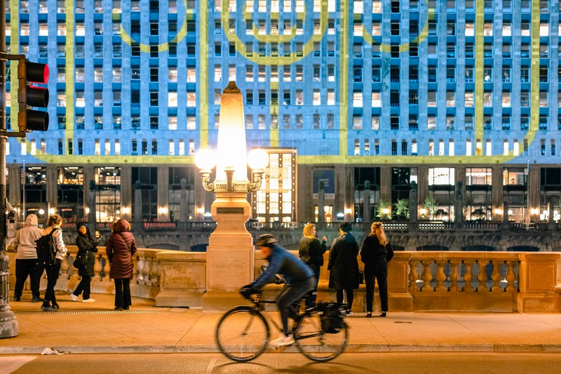 Art on the Mart is the world’s largest public art display, says executive director Cynthia Noble, who adds that the best place to view each night at 9pm through July 6th is on the Riverwalk, at the Jetty in between Wells and Franklin.