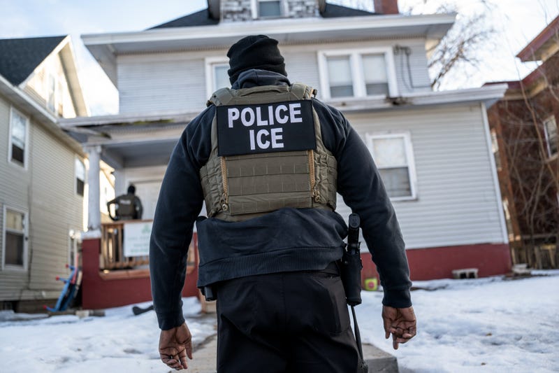 A federal law enforcement agent outside a home during a raid in south Minneapolis, Minnesota, US, on Tuesday, Jan. 13, 2026