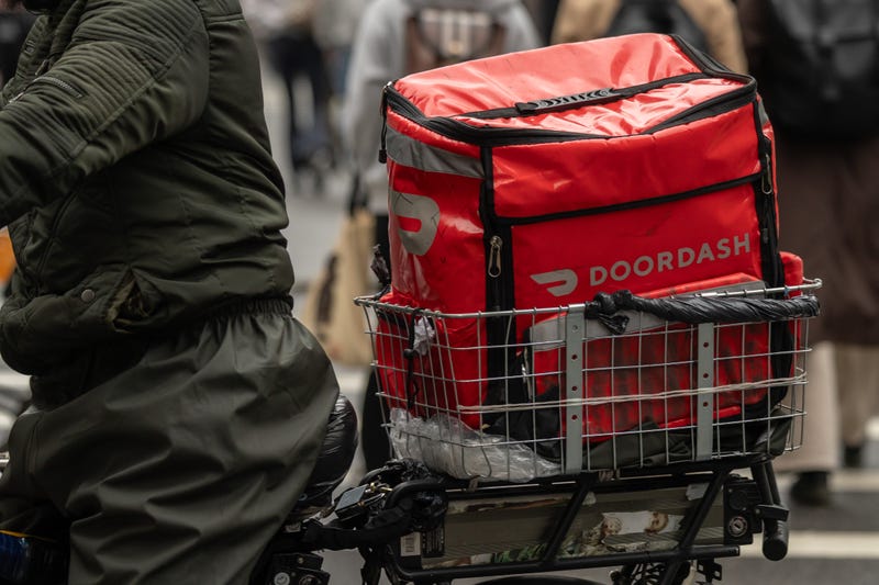 A delivery worker carries a DoorDash bag during a delivery in New York.