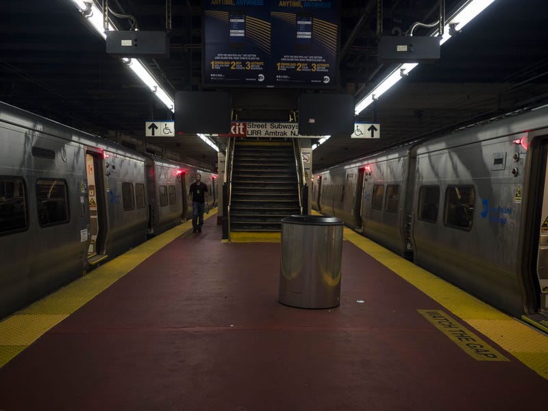 Trains on a platform inside Penn Station in New York City.