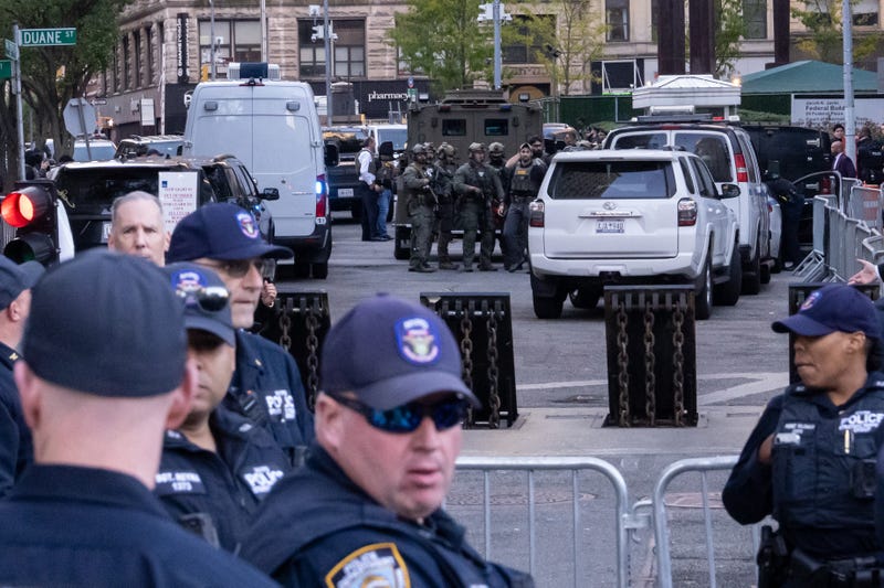 Heavily armed federal agents stand by an armored vehicle as NYPD Strategic Response Group agents stand by outside of 26 Federal Plaza on Oct. 21, 2025 in New York.
