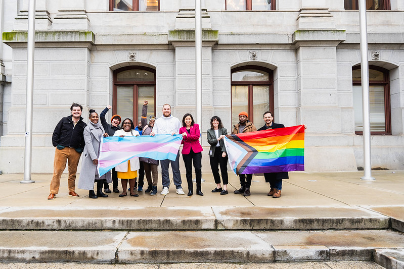 Members of Philadelphia's LGBTQ communities stand with Councilmember-at-Large Rue Landau (center, pink jacket) outside of City Hall.