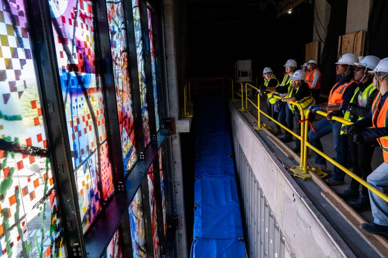 Crews work to install one of 35 stained glass panels for “Uprising of the Sun.”