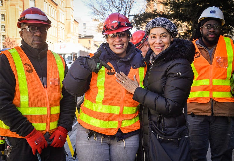 The NYC Transit employees worked together to lift the grate and grab the ring.