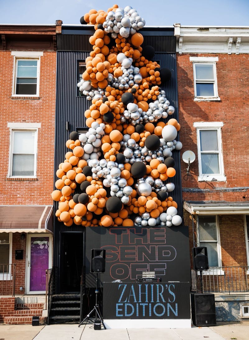 A cascade of hundreds of balloons — orange, silver and black — poured from the front of the home.