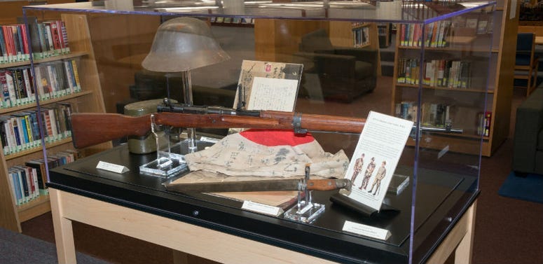 Accompanying Sakakida’s sword are intercepted documents and confiscated items including a Japanese rifle, bayonet and helmet.
