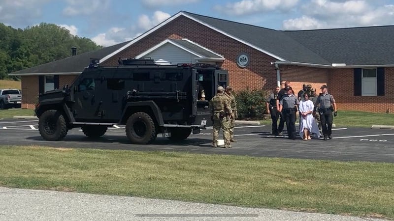Flanked by armed troopers and border patrol officers, wearing something like a hospital gown, Danelo Cavalcante is escorted to an armored vehicle waiting to take him to SCI Phoenix.