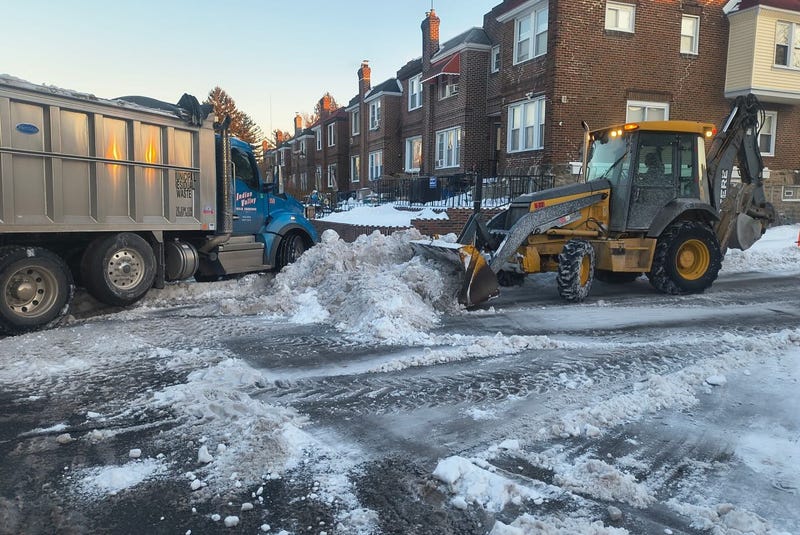 A bulldozer and truck involved in snow removal.