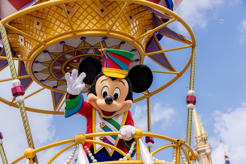 FILE - Mickey Mouse waves to the crowd during the “Disney Festival of Fantasy Parade” in Magic Kingdom Park at Walt Disney World Resort in Lake Buena Vista, Fla. The parade returned to the park Wednesday, March 9, 2022, after a nearly two-year absence. 