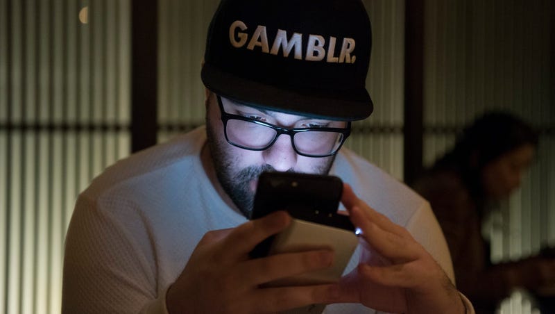 Robert Gorodetsky monitors the sports he places bets on via his phone in 2017