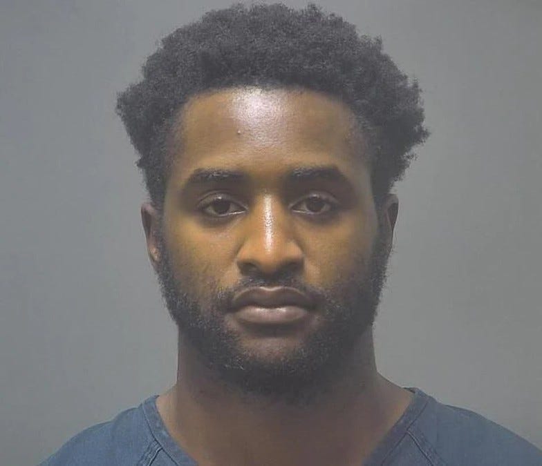 Black man in 20s not smiling with black hair and black beard