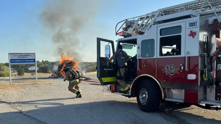 Burning trash pile dumped on the roadside in White Settlement