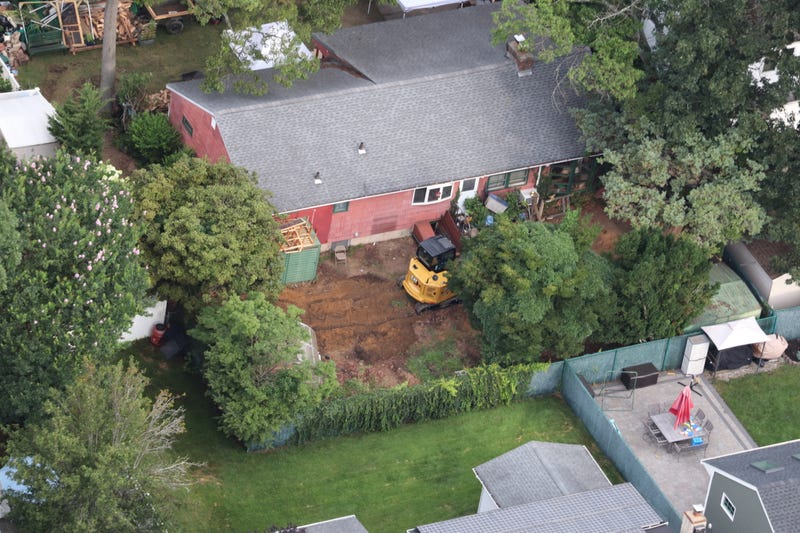 An excavator was seen in the backyard of Rex Heuermann's house in Massapequa Park on Monday