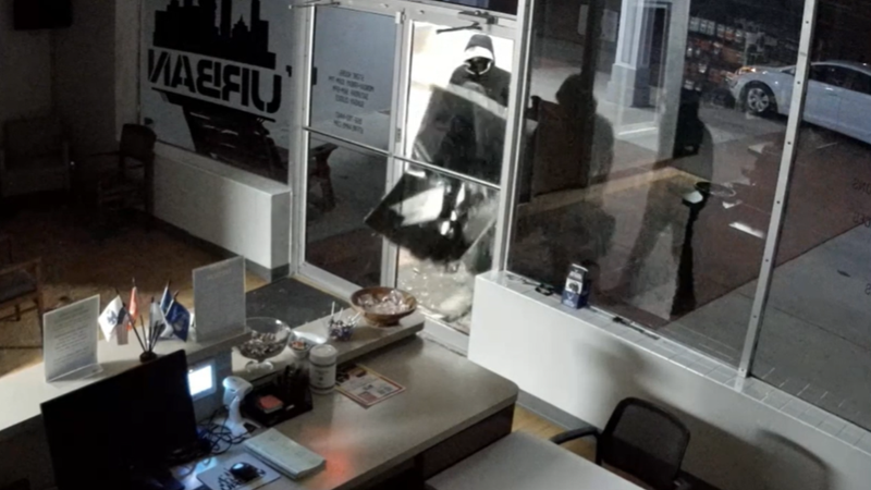 Video surveillance images show four suspects, dressed in black, with face coverings.
