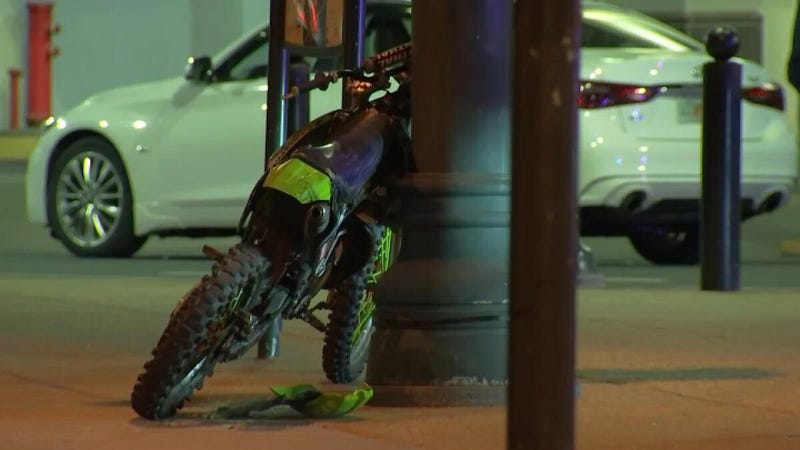 A small motorcycle involved in an accident on the Benjamin Franklin Parkway leans against a lamp post.
