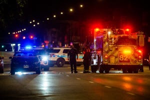 A Chicago Fire Fighter looks at a shot up vehicle which was involved in a shoot out with an off-duty police officer, Saturday morning in the Burnside neighborhood.