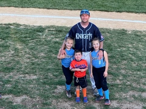 Patrick, coaching at Community Night for North Penn, stands with his kids on the field before the game