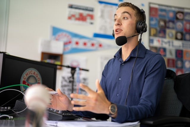 Man sits at a desk with a microphone