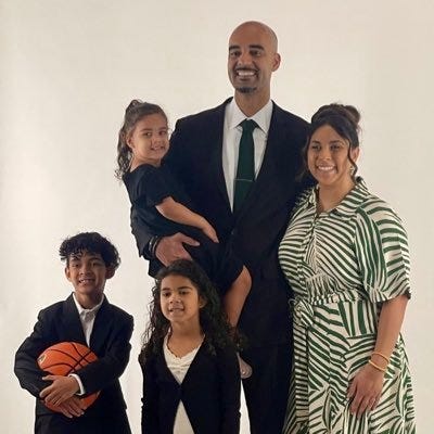 Cleveland State men's basketball coach Rob Summers (in suit) poses with family members during a photo shoot.