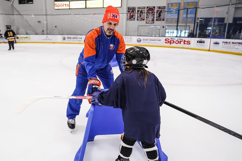 Radek Martinek helps a youngster learn to skate.