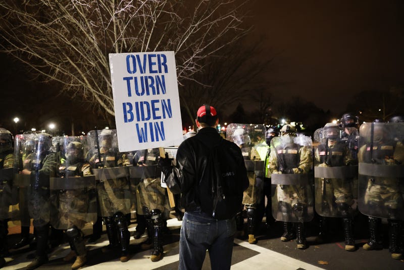 Members of the National Guard and police keep a small group of Trump supporters away from the Capitol after the Capitol riots, Jan. 6, 2021.