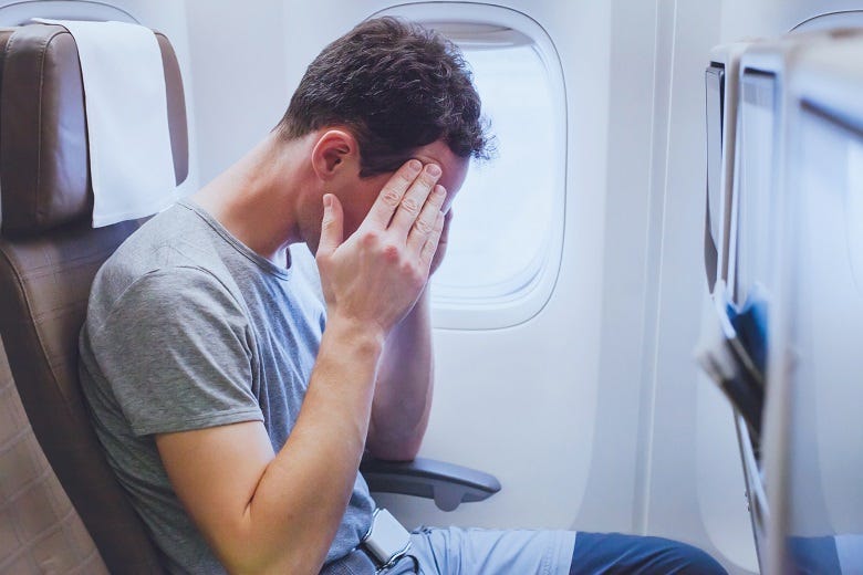 male airline passenger stressed out on flight