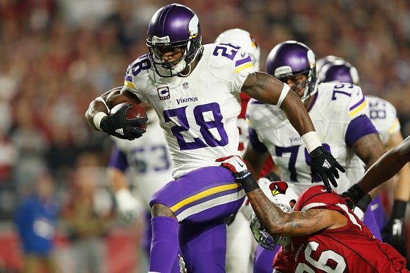 Adrian Peterson runs through a defender with the Vikings.