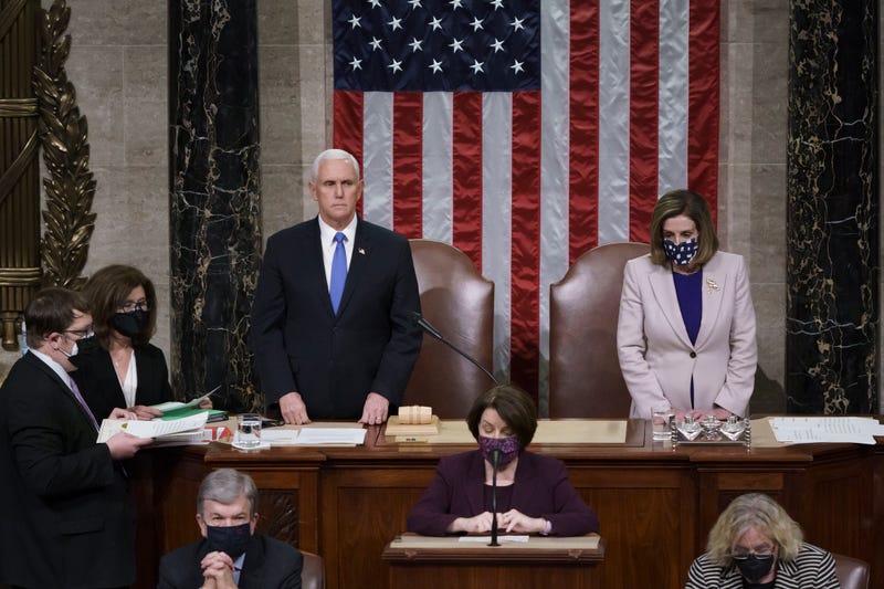 Vice President Mike Pence and Speaker of the House Nancy Pelosi, D-Calif., read the final certification of Electoral College votes cast in November's presidential election during a joint session of Congress after working through the night, at the Capitol in Washington, Thursday, Jan. 7, 2021.