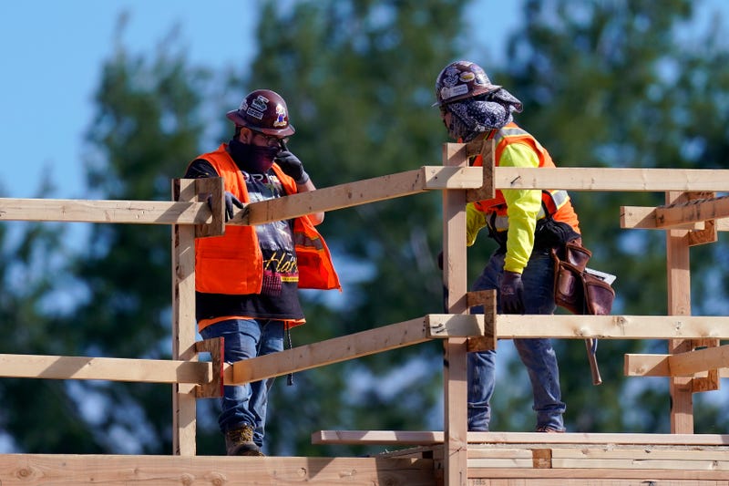 Construction workers talk at a USA Properties Fund site, Tuesday, Feb. 2, 2021, in Simi Valley, Calif