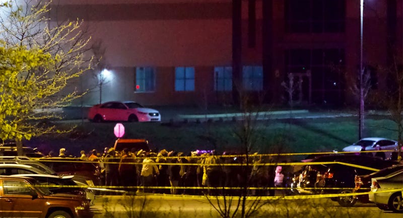 People stand outside a FedEx facility near Indianapolis International Airport after a shooting with multiple victims was reported late Thursday night, April 15, 2021